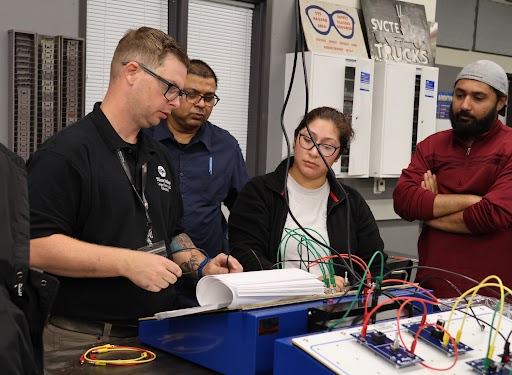 A group of people looking at equipment